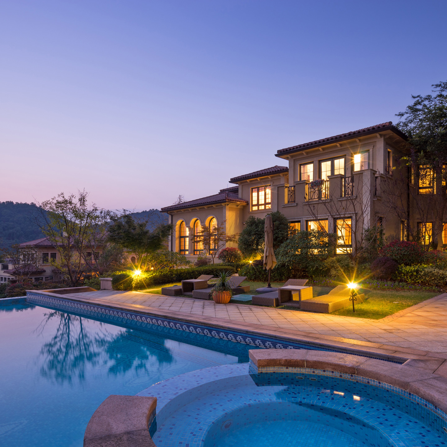 night scene of modern waterfront villa with meadow outdoors and illuminated sky